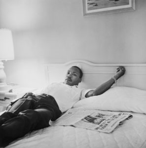 The Mountaintop man relaxing on the bed with newspaper
